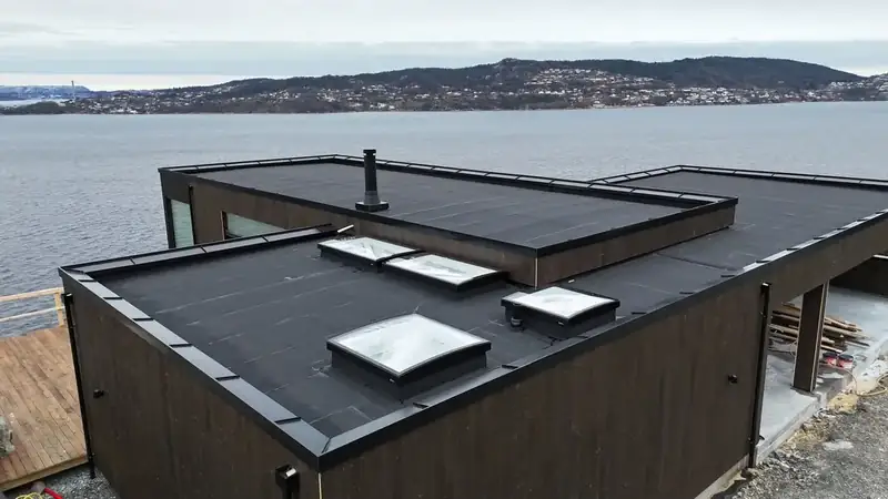 Blikkenslagerarbeid – beslag på flatt tak ved fjorden i Bergen
